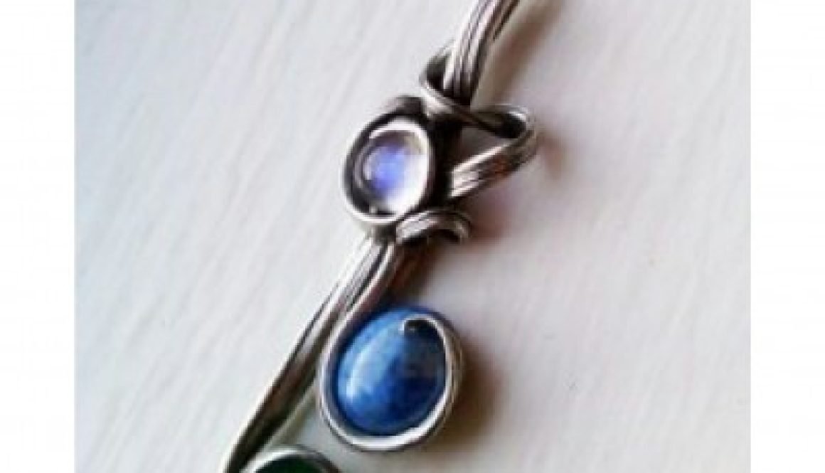 Pendant with a rainbow moonstone, denim lapis blue stone, and a green stone.