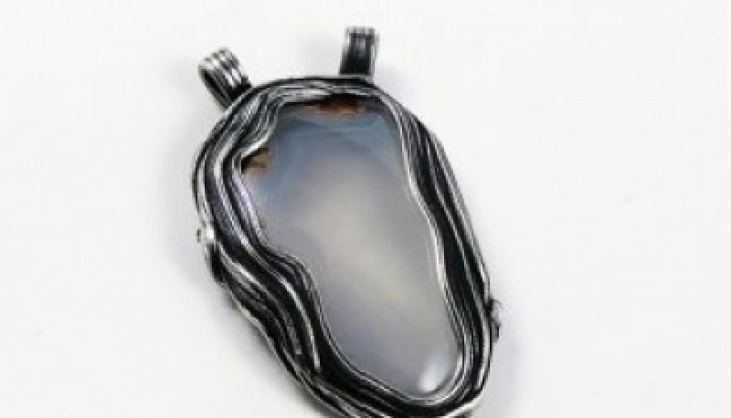 Silver pendant and blue agate stone in the shape of lake Tahoe.