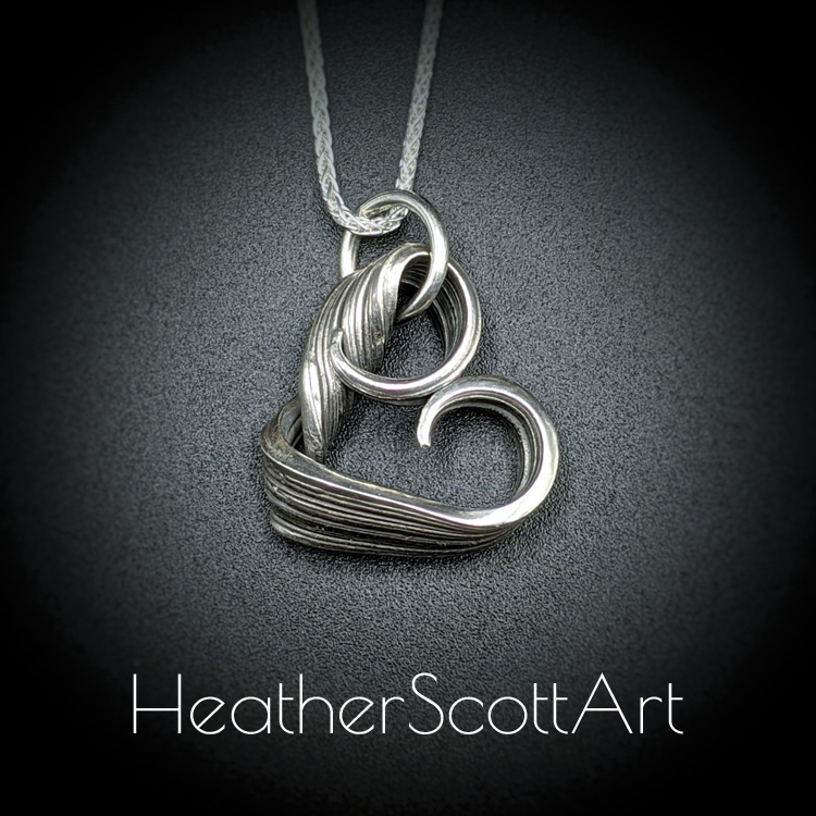 Sterling Silver heart with twisting sides and linear textures.